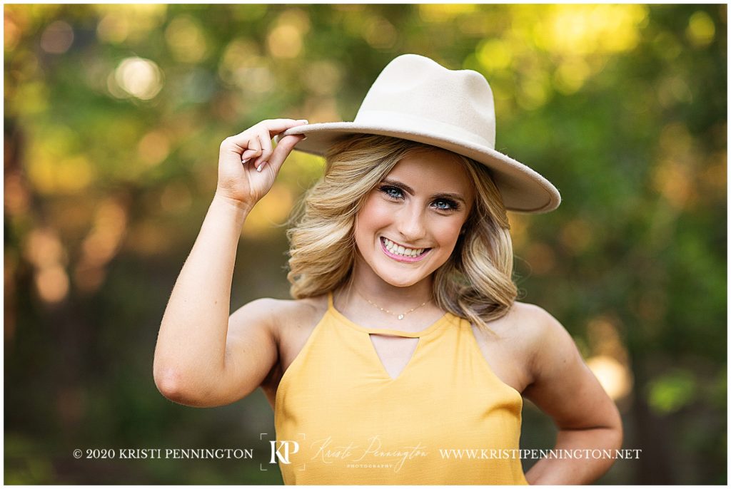 picture of smiling girl wearing a hat and yellow top