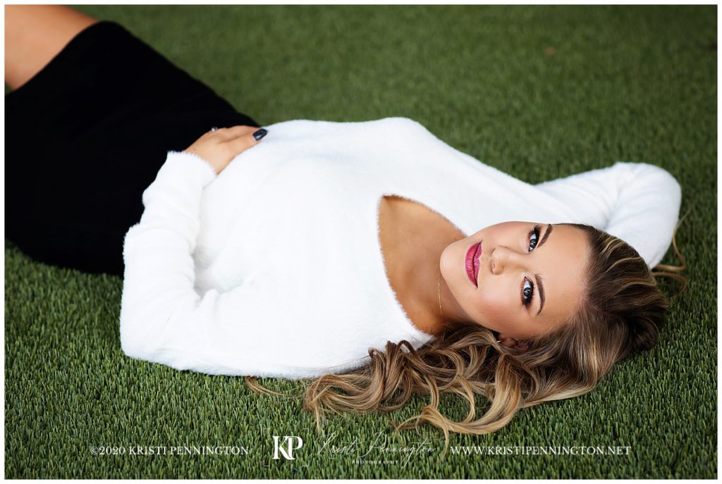 Senior girl portrait in downtown Dallas laying pose in the grass